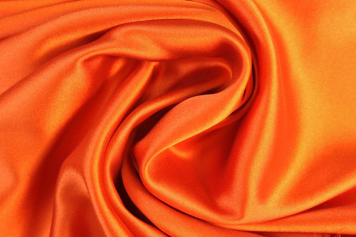 Фиона показывает себя на фоне оранжевой ткани